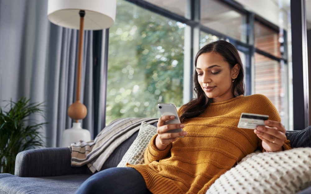 omnichannel shopping woman using mobile phone and credit card at home