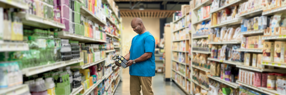 Man reading the description of multi-pack product in a store