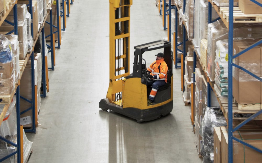 worker operating forklift in warehouse
