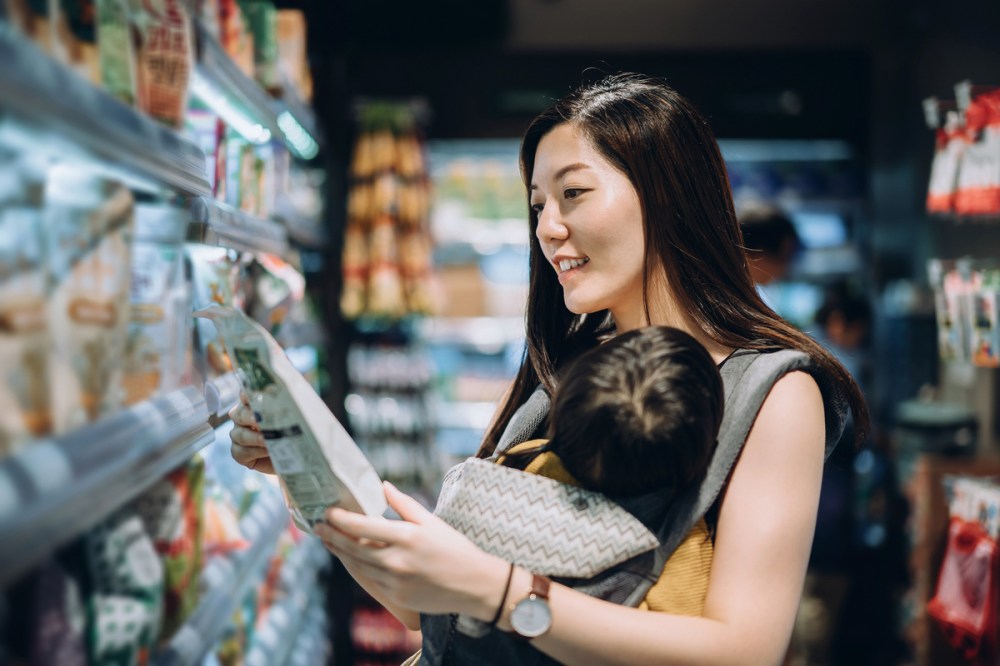 Woman with baby shopping for groceries