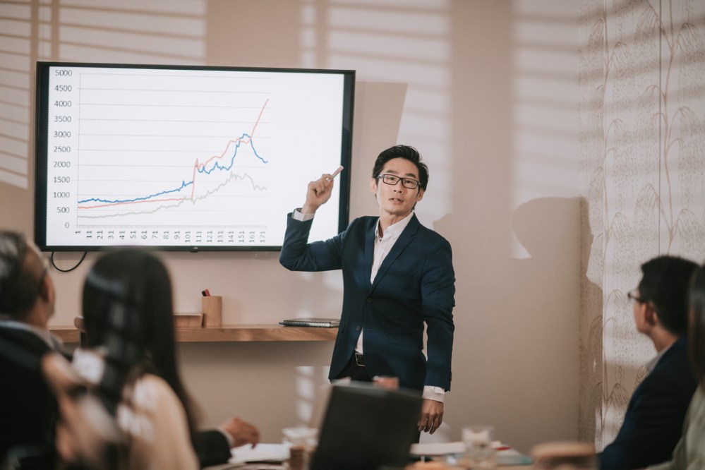 A man reviewing retail data during a presentation for work.