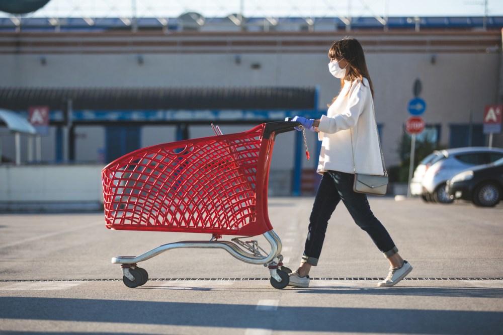 masked shopper pushes a grocery cart