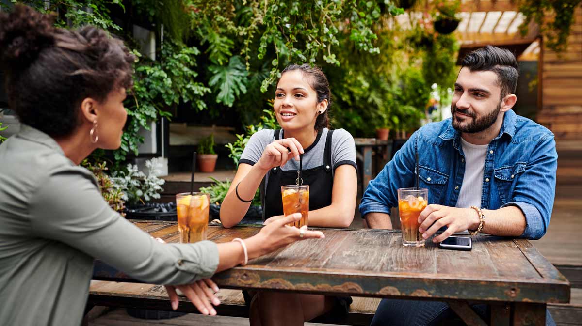 People sitting at a picnic table having drinks