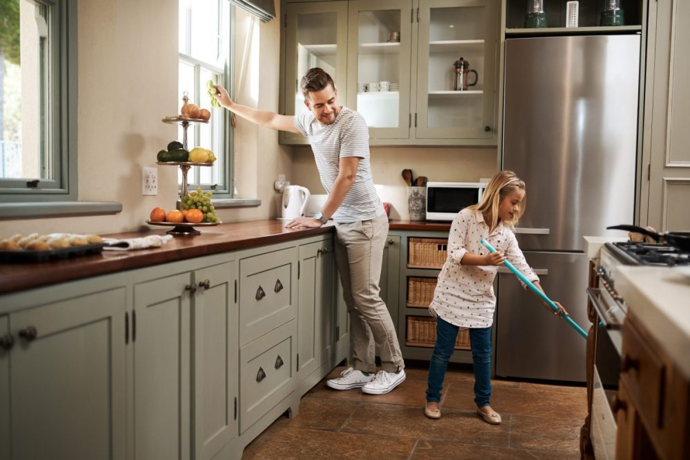 A father and daughter cleaning their home.