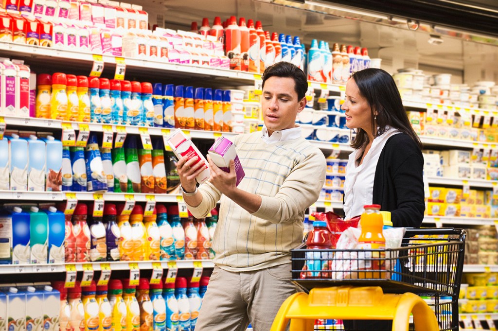 couple shopping in grocery store looking at item assortment on the shelf