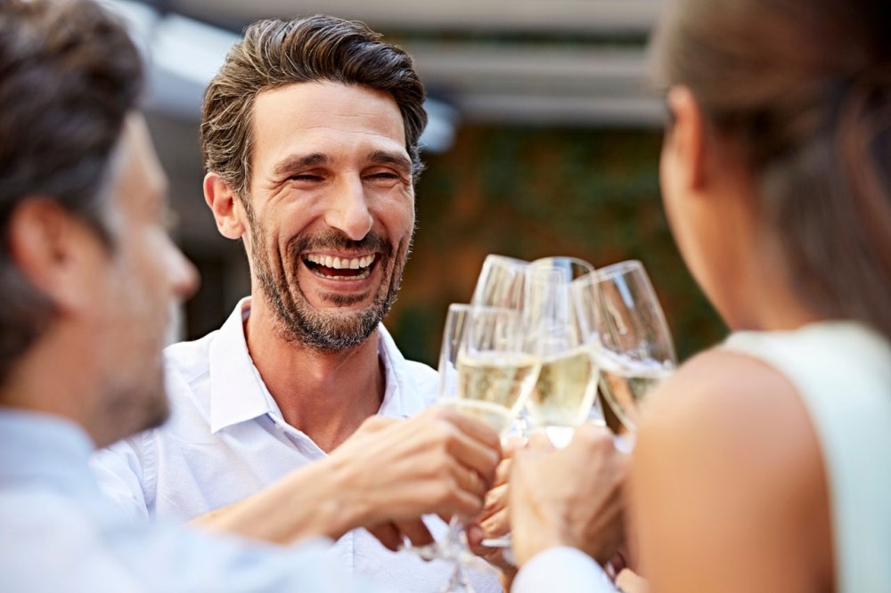 Three people clink champagne glasses in celebration