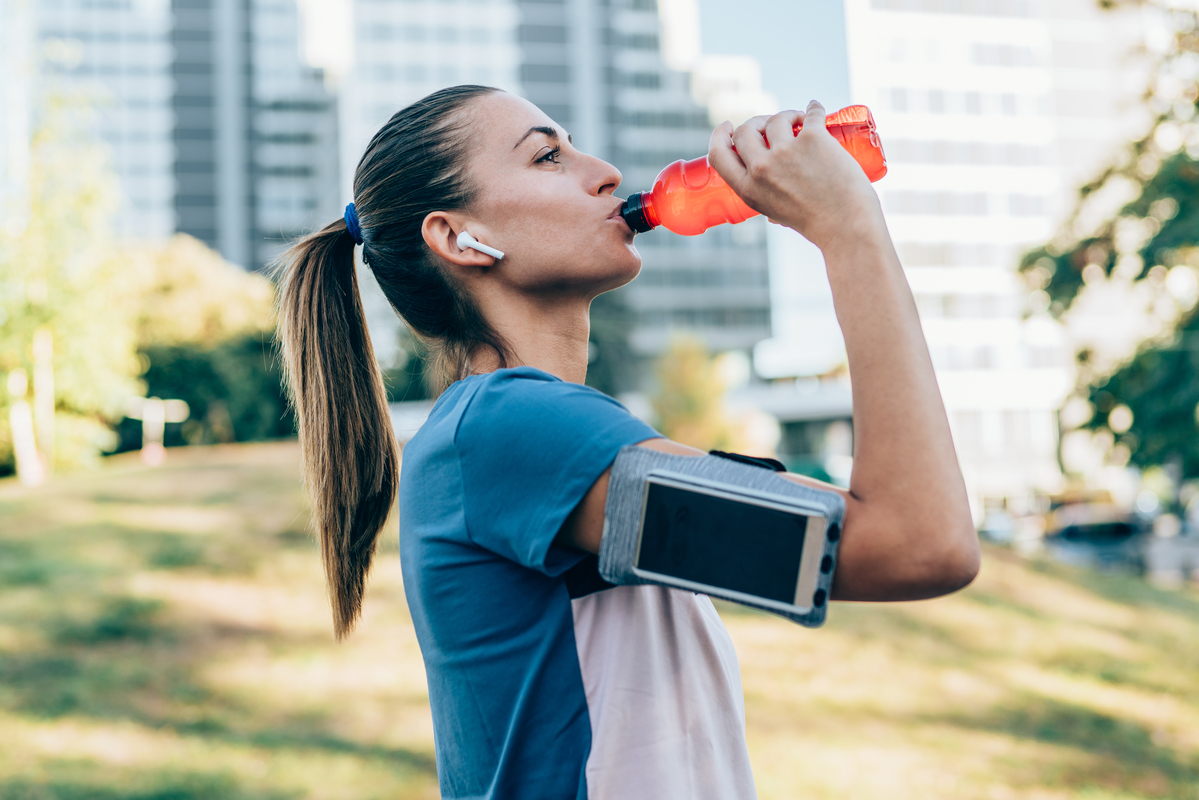 Woman drinking from a water bottle outside