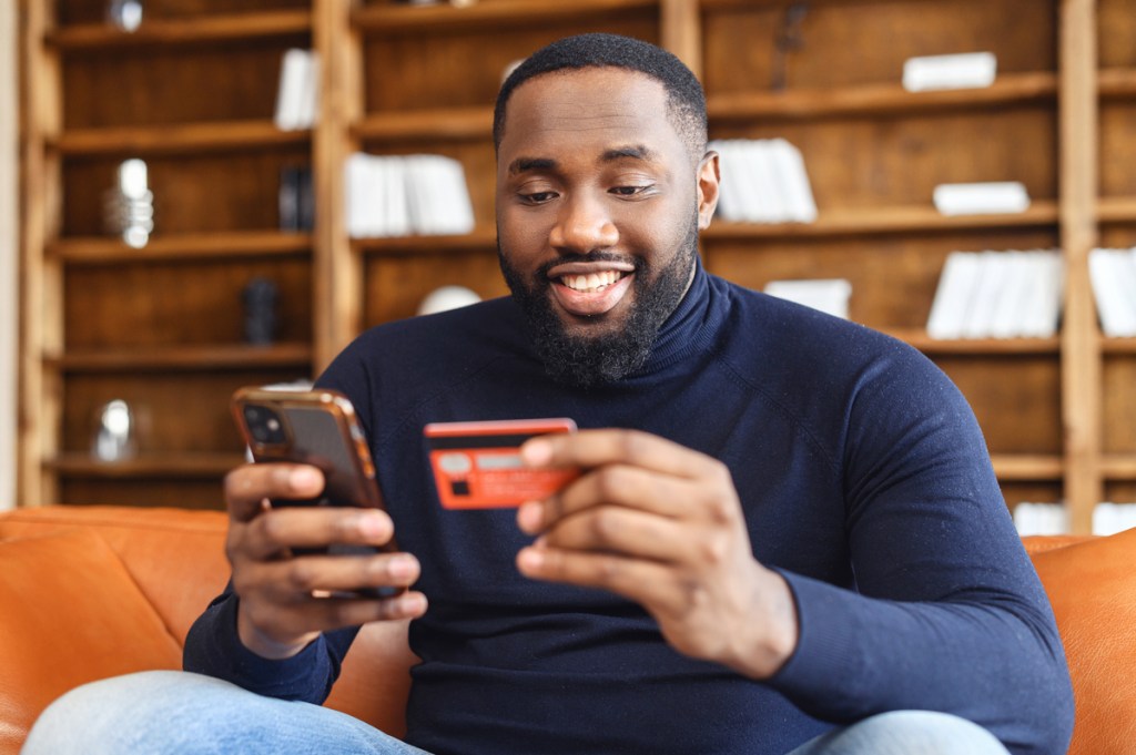 Happy Black consumer using a smartphone for online shopping