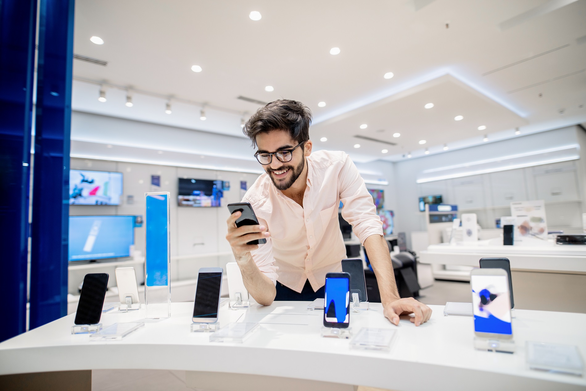 man in store, playing with smartphone