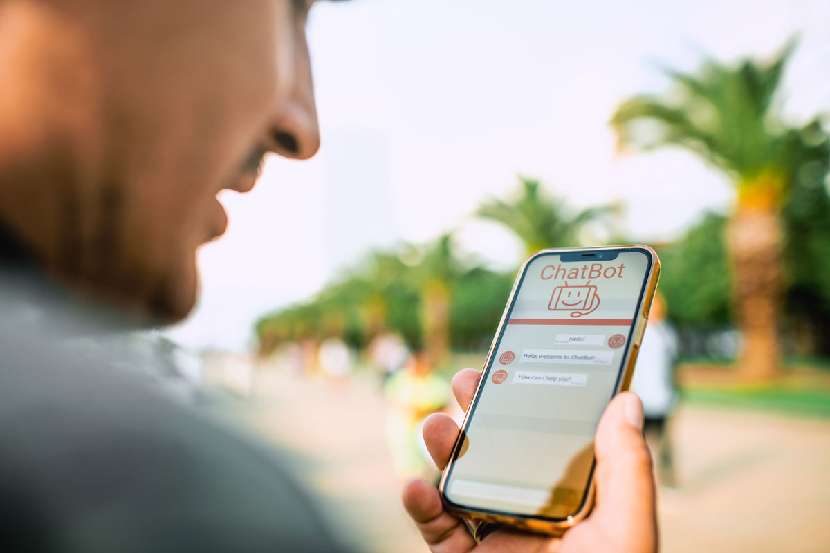 Man holding a mobile phone with a chatbot interface on screen