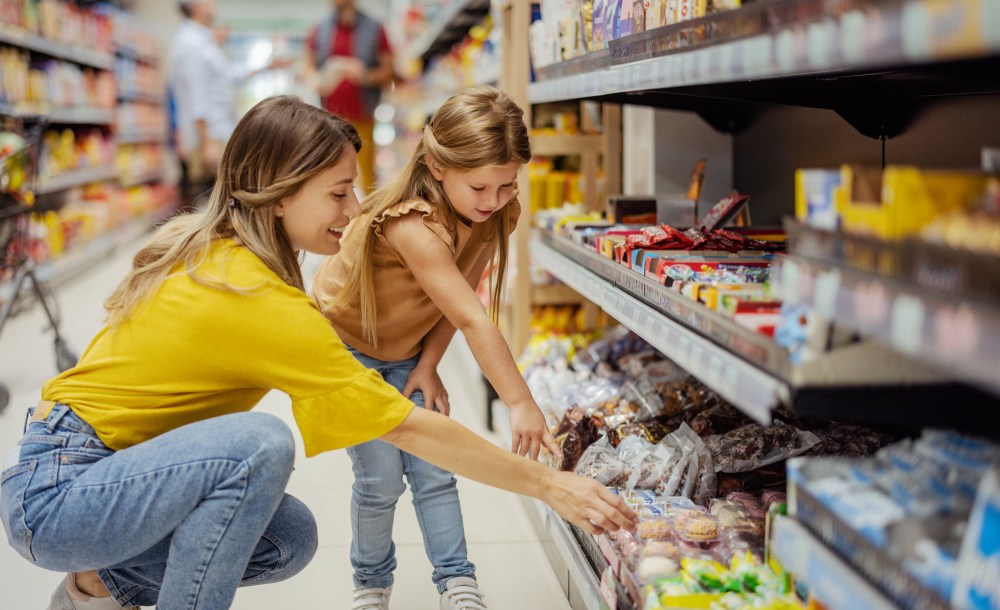 Mother and daughter at the grocery store shopping sweets