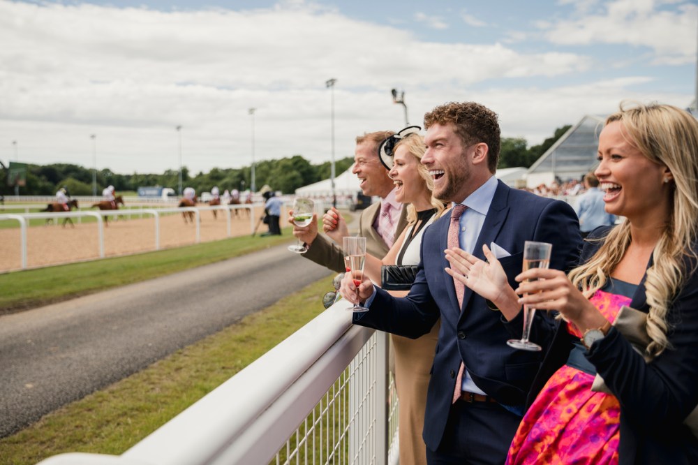 Couples enjoying a day at the races. Two couples enjoying a drink at the races.