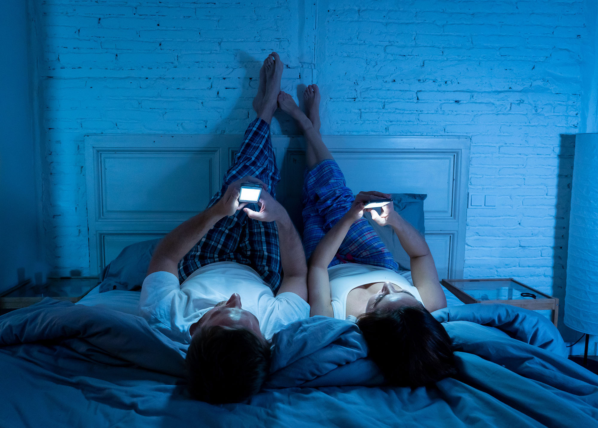 Chapter 1 of the Consumer outlook 2026 report shows a couple looking at their phones in bed