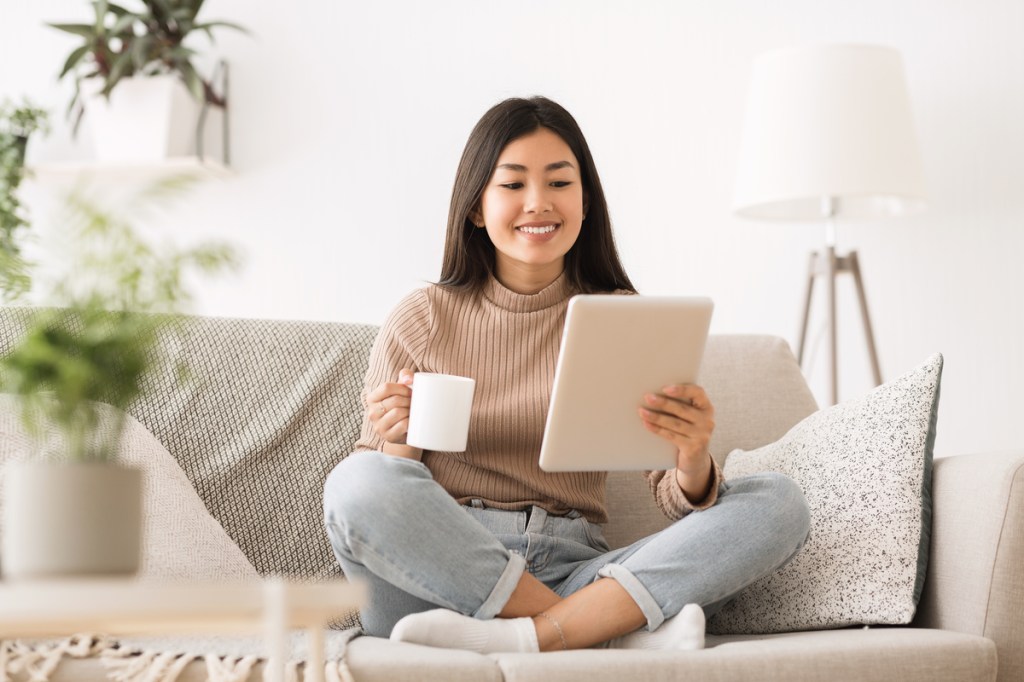 Cheerful,Girl,Reading,E-book,On,Digital,Tablet,,Drinking,Morning,Coffee