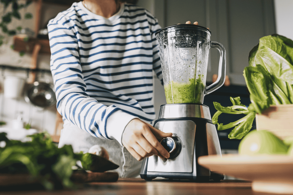 a women making green juice